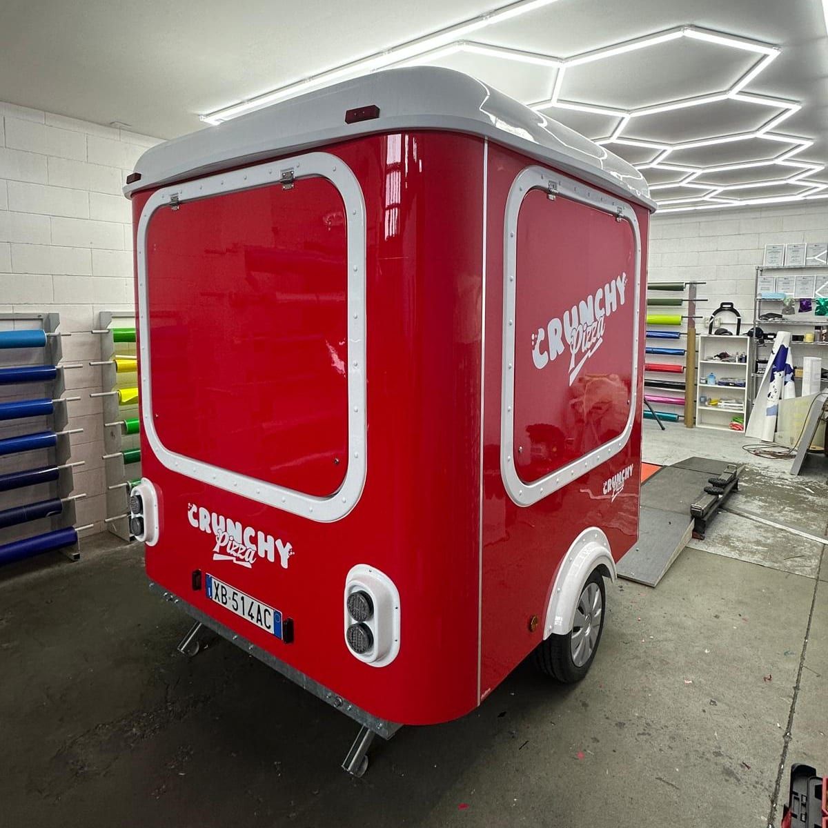 Food truck rimorchio con livrea rossa e logo Crunchy Pizza, vista di tre quarti posteriore