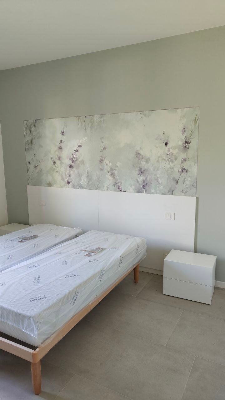 Camera da letto con pannello decorativo floreale sopra la testata