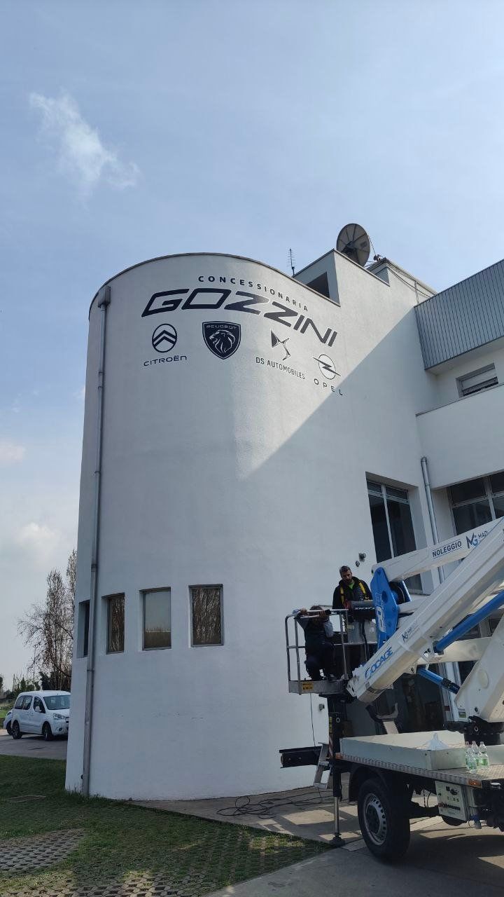 Grafica a parete Concessionaria Gozzini con i loghi Citroën, Peugeot, DS e Opel in installazione