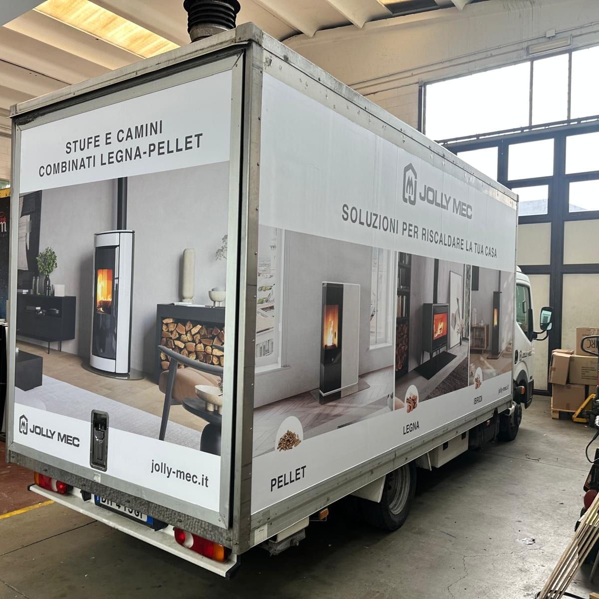 Camion con cassone decorato con immagini di stufe e camini e logo Jolly Mec