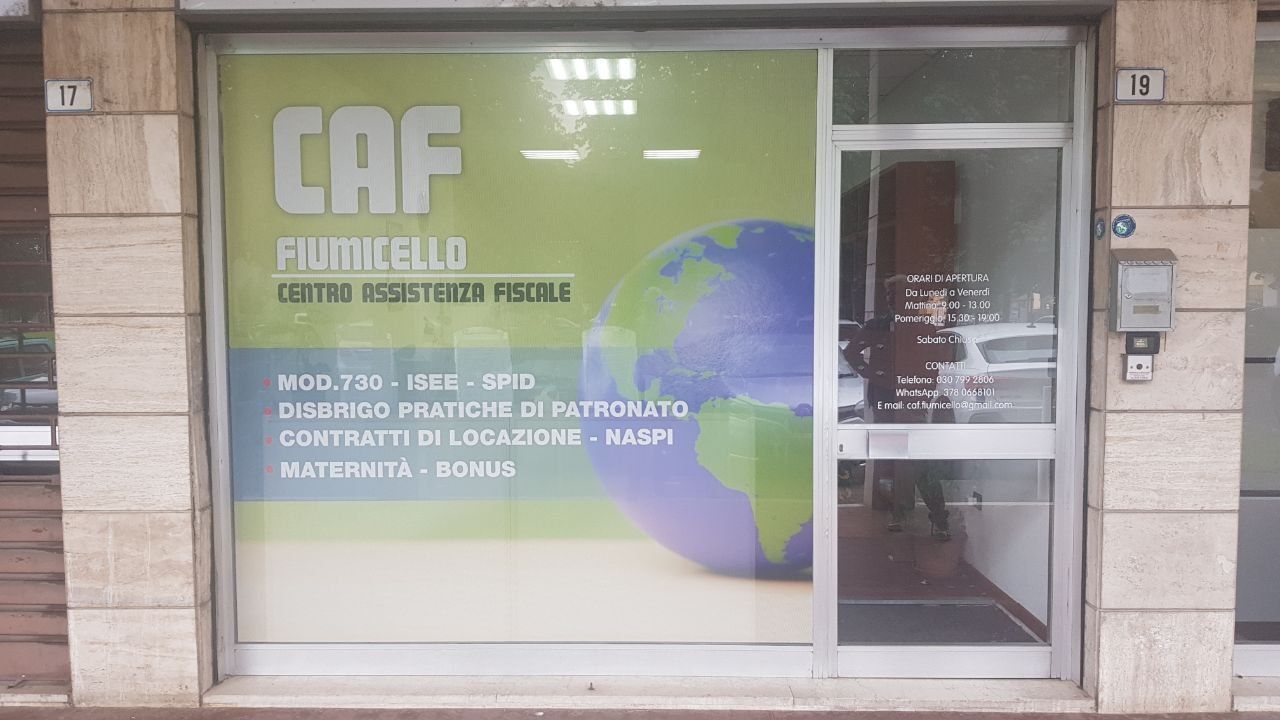 Vetrina del CAF Fiumicello con vetrofania microforata che elenca i servizi